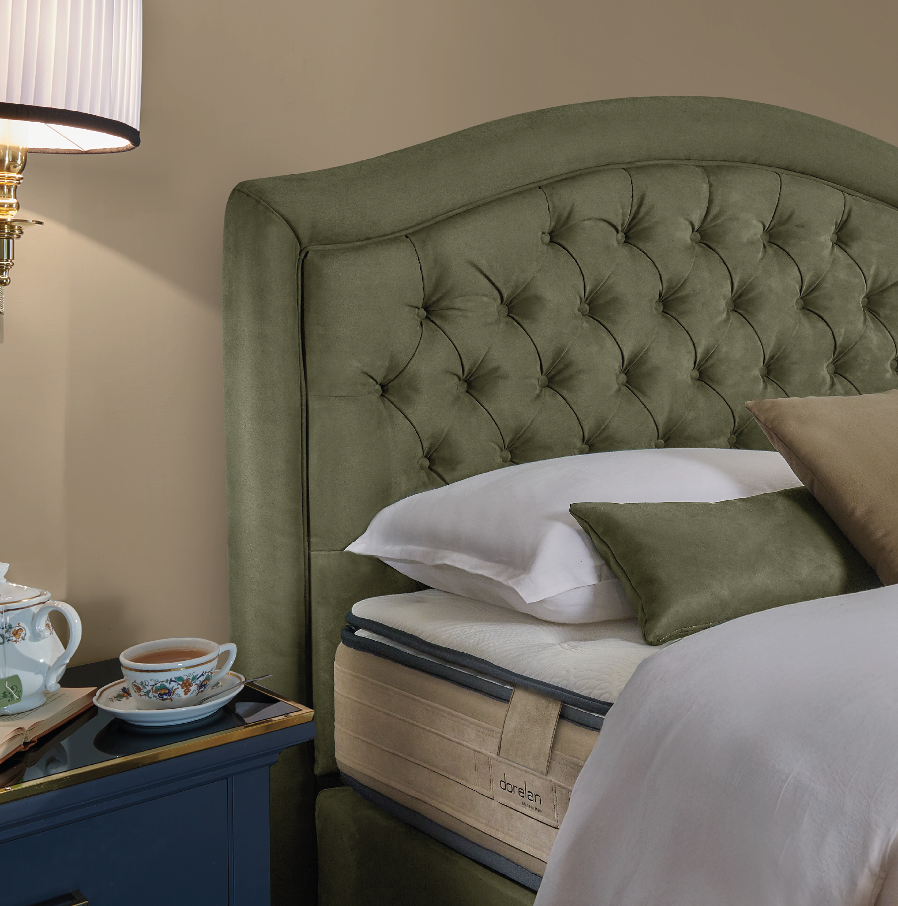 Bed with green velvet button-tufted headboard and bedside tea set