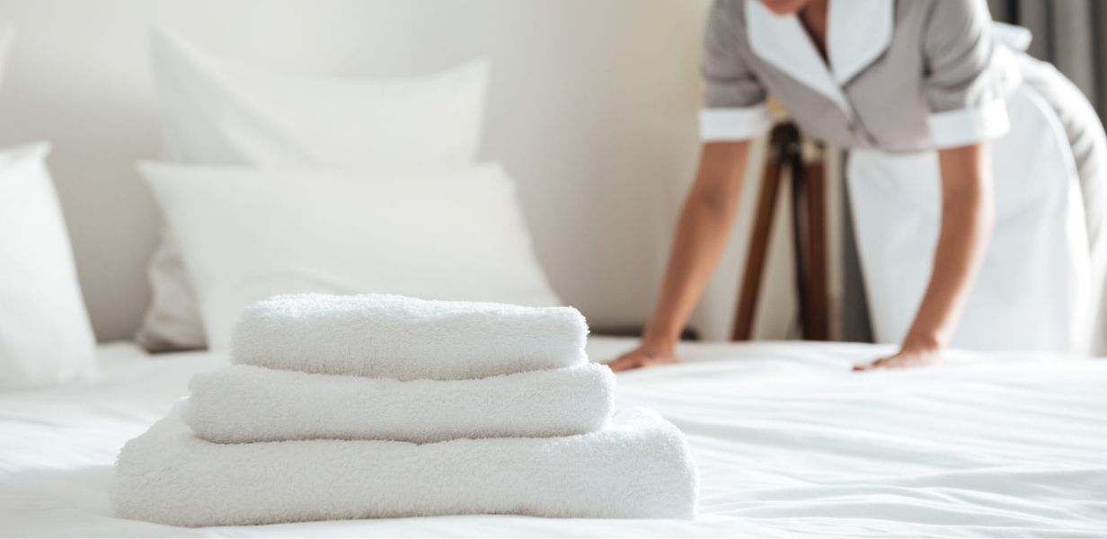 Woman making the bed in a hotel room
