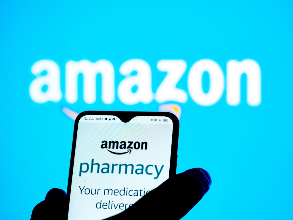 Téléphone. ayant une page ouverte sur Amazon pharmacy, sur un fond comprenant le logo d'Amazon