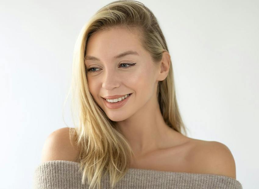 woman smiling looking down in off the shoulder top