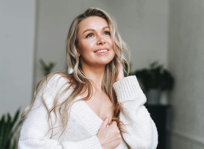 woman in white cardigan looking upwards