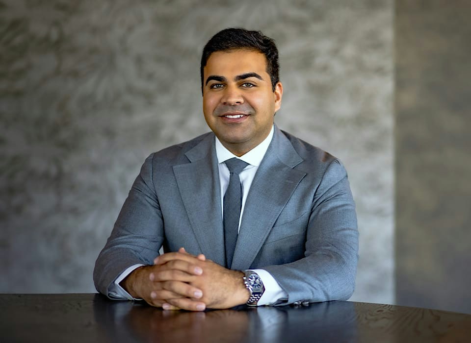 Dr. Chopra in suit sitting down