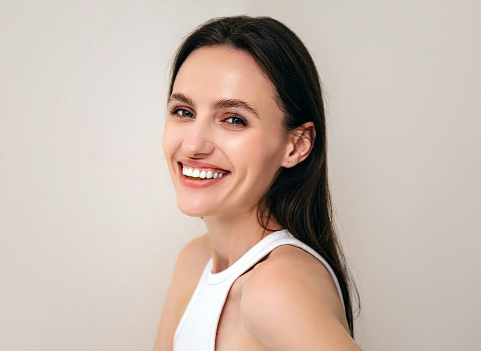 woman smiling in white tank top