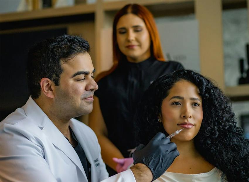 Dr. Chopra injecting into patient's lip