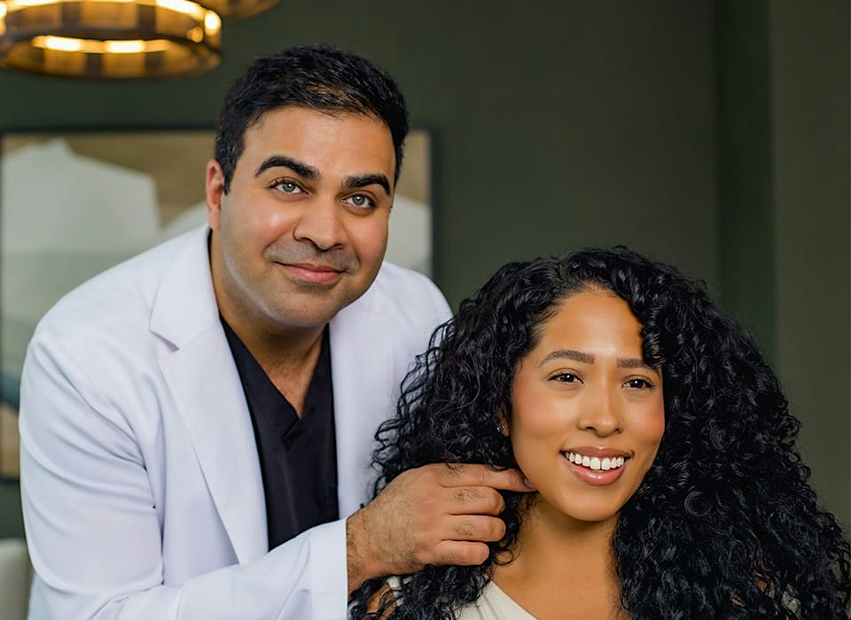 Dr. Chopra pointing at patient's neck