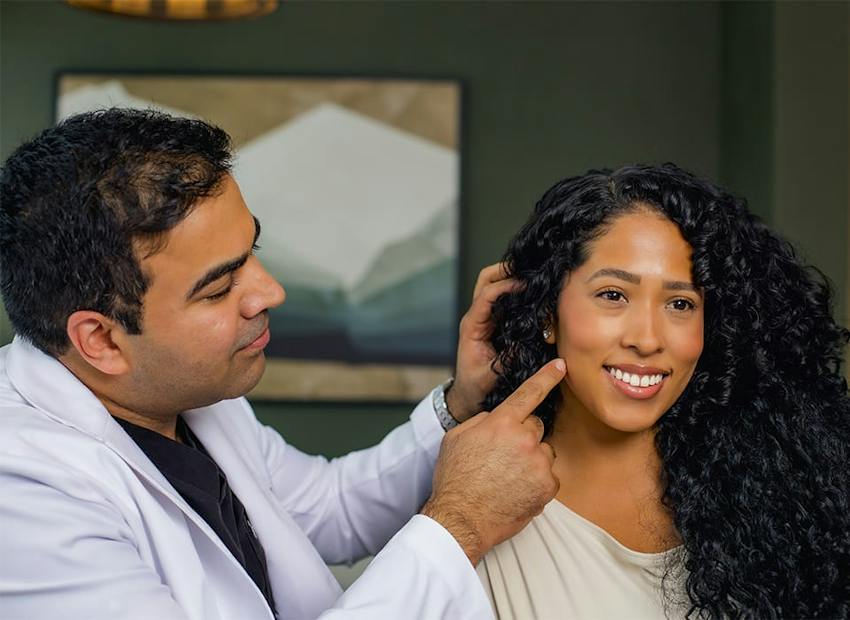 Dr. Chopra pointing to patient's jaw