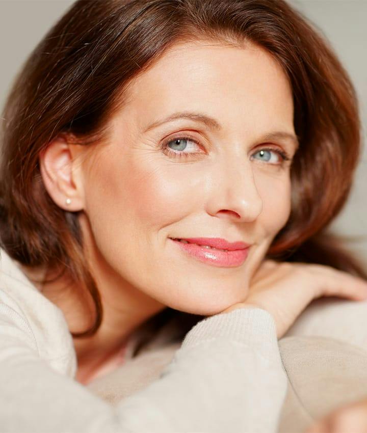 close up of woman smiling and leaning on her hand