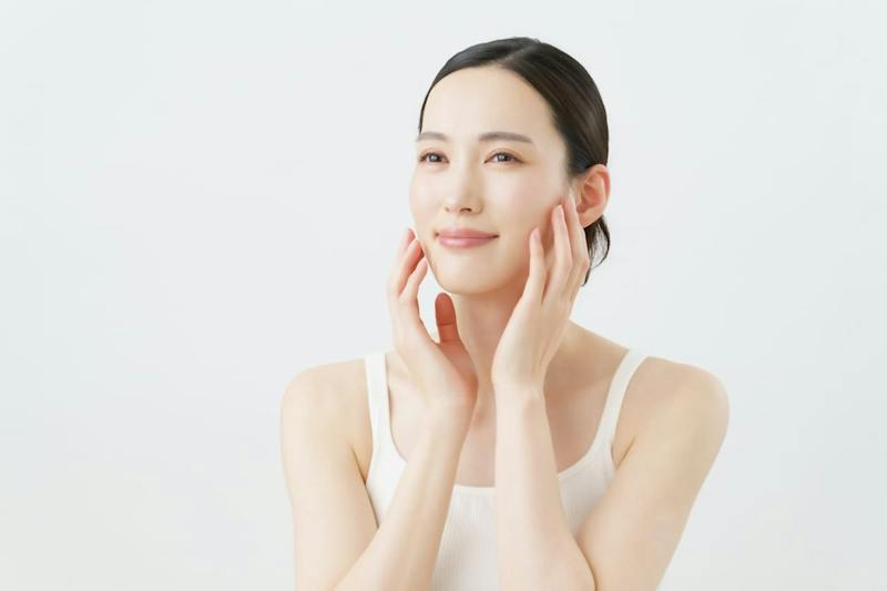 Woman smiling and feeling her cheeks