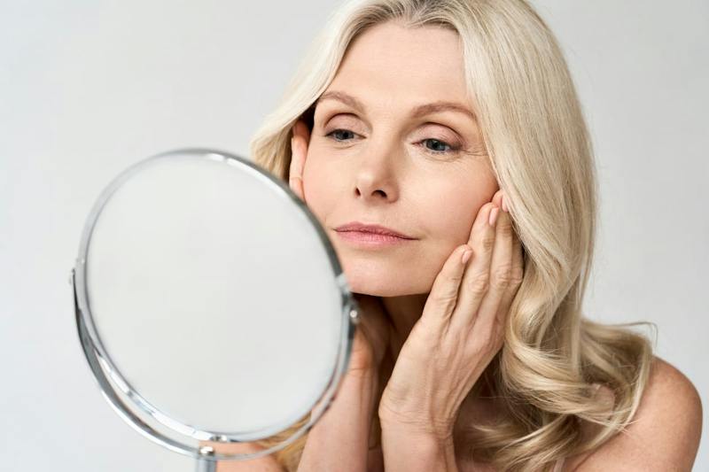 Woman examning her face in a mirror