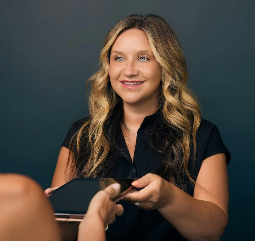 Team member handing over a tablet