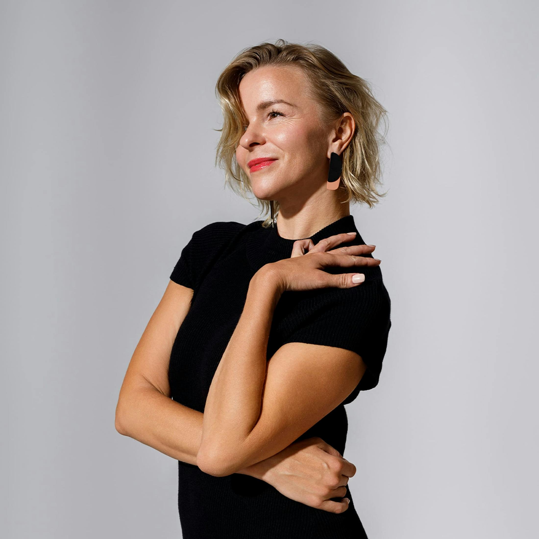 Woman smiling with hand on shoulder