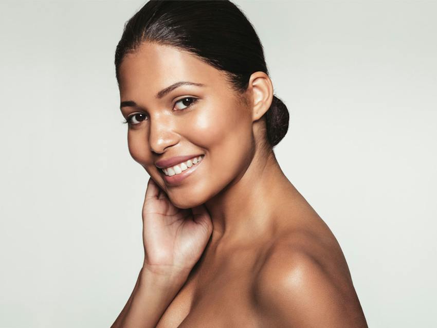Woman smiling and touching her face
