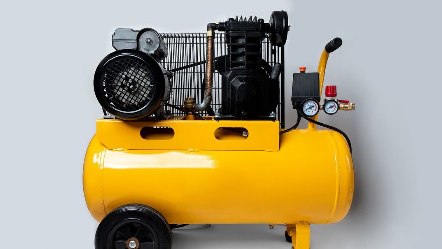 A small compressor with a yellow tank, for home and workshop use