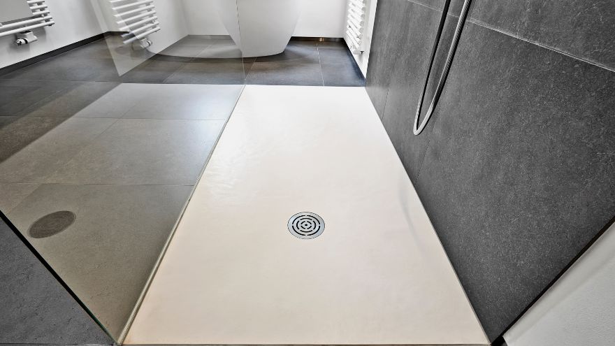 Kratka punktowego odpływu prysznicowego na środku jasnej posadzki kabiny w nowoczesnej łazience