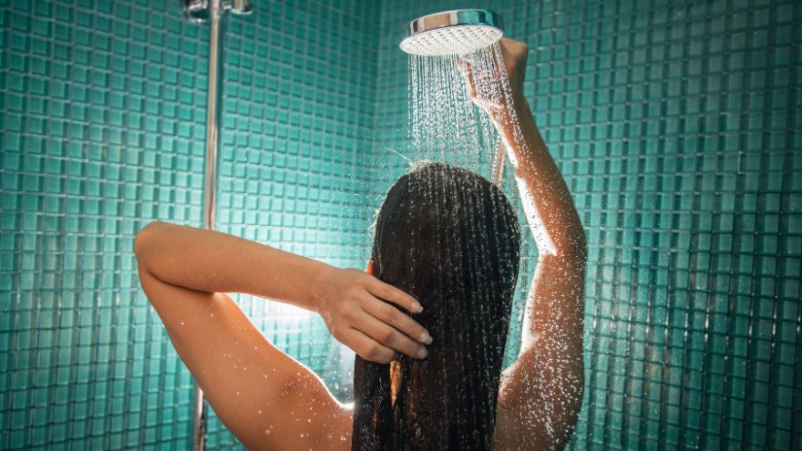 Kobieta bierze prysznic w turkusowej łazience