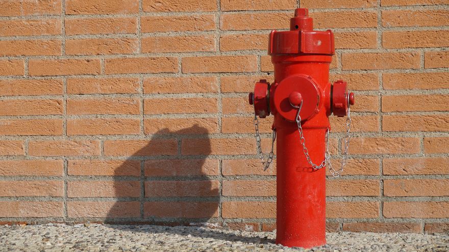 hydrant przy ceglanej scianie