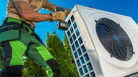 Instalator z wkrętarką przy pompie ciepła