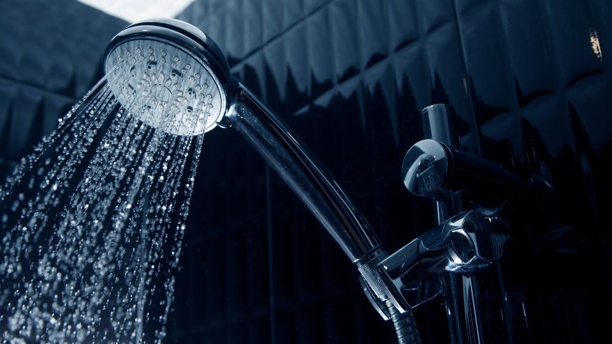 Woda ze słuchawki prysznicowej w ciemnej łazience