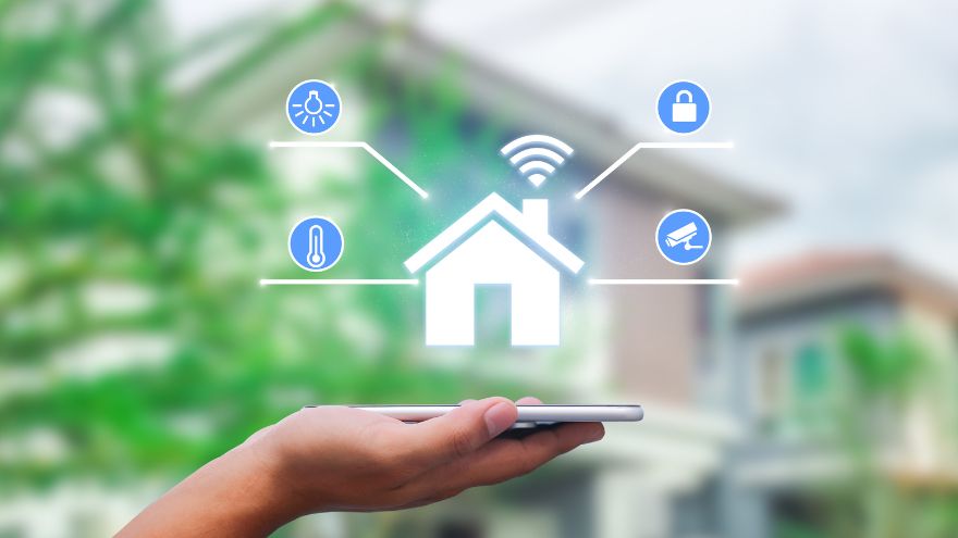 Ręka z telefonem z systemem smart home na tle domu