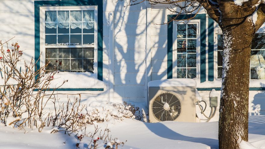 Pompa ciepła przed domem w ogrodzie zimą