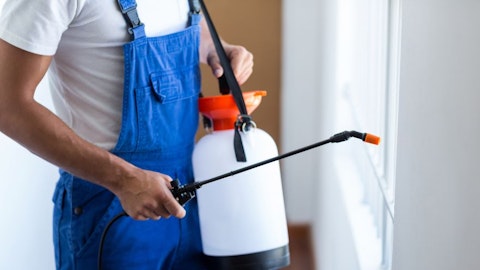 Instalator z opryskiwaczem przy ścianie