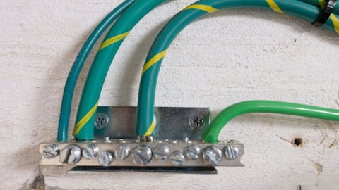 Kabely a vodiče připojené k vyrovnávací sběrnici na stěně