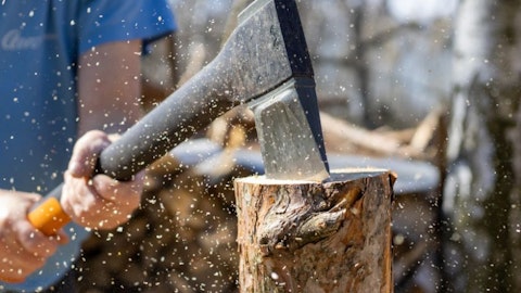 Drevorubač sekerou reže polená palivového dreva