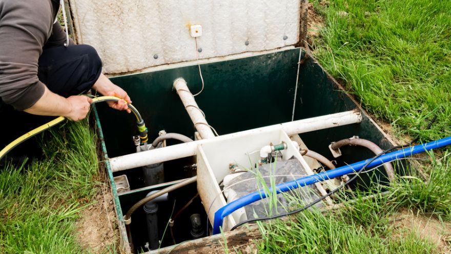 Очисник вигрібних ям очищує побутову очисну споруду в саду Szambiarz oczyszcza przydomową oczyszczalnie ścieków w ogrodzie