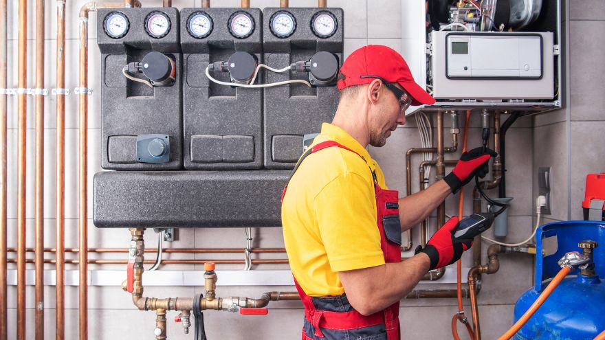 Instalator w kotłowni przy instalacji gazowej z rurą do gazu PE