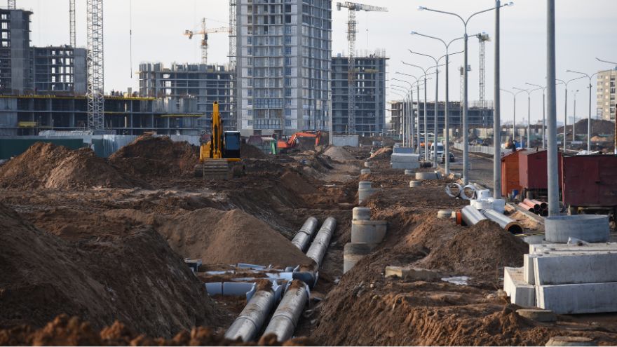 Rury ułożone w systemie drenażu podziemnych wód gruntowych i kanalizacji deszczowej na tle budującego się miasta