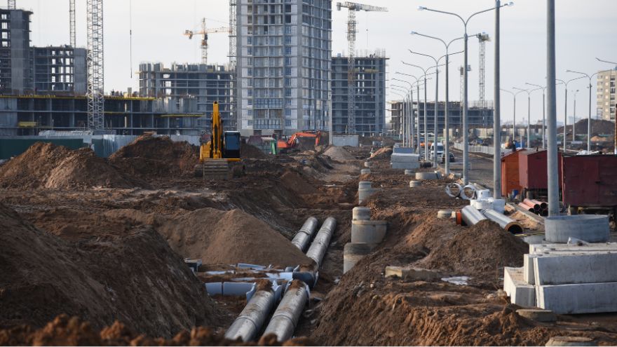 Rury ułożone w systemie drenażu podziemnych wód gruntowych i kanalizacji deszczowej na tle budującego się miasta