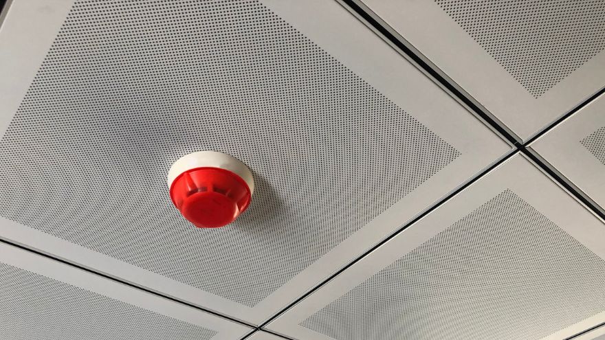 Sygnalizator akustyczny systemu alarmowego na suficie w biurze