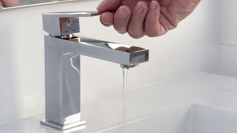 Instalator odkręca wodę z baterii łazienkowej kaskadowej na zlewie