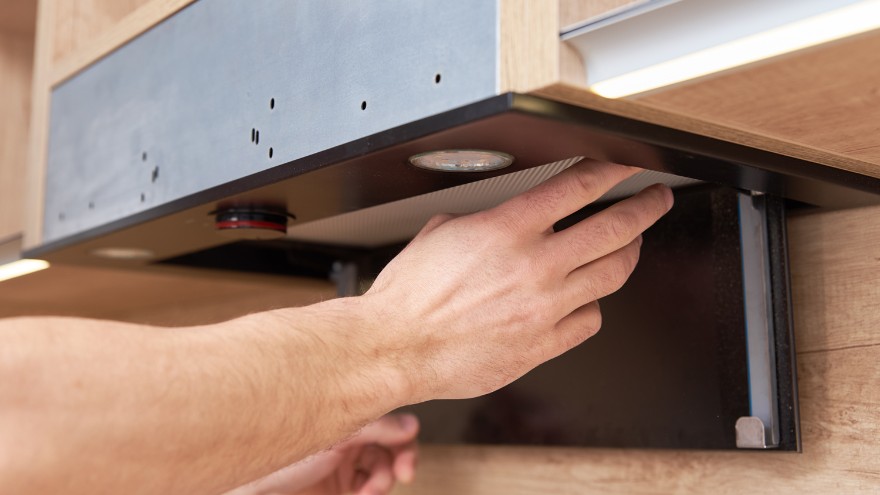 Instalator zakłada siatkę ochronną na opak w kuchni z filtrem węglowym
