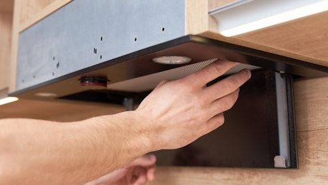 Instalater postavlja zaštitnu mrežu naopako u kuhinju sa ugljeničnim filterom
