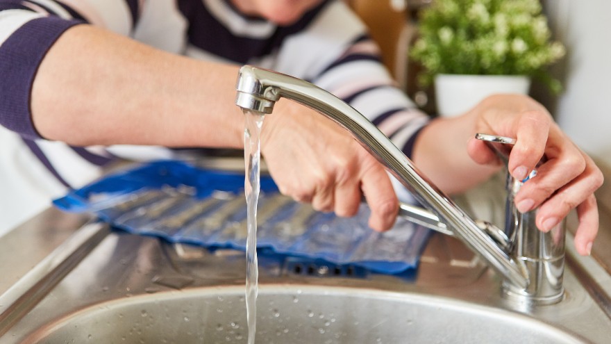 Hydraulik naprawia kran na zlewie kuchennym jednokomorowym z ociekaczem