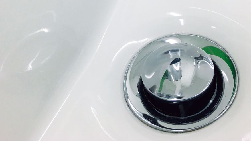 Srebrny korek klik klak w ceramicznej umywalce w łazience