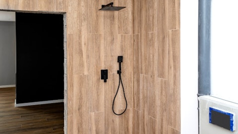 Czarny matowy zestaw prysznicowy podtynkowy w łazience z drewnianymi panelami
