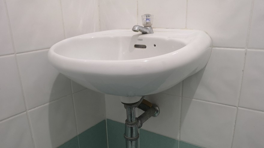 Umywalka ceramiczna w łazience narożna z baterią na ścianie