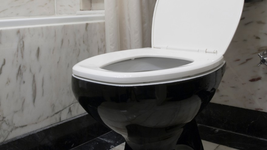 Ceramiczna czarna muszla klozetowa z białą deską w łazience