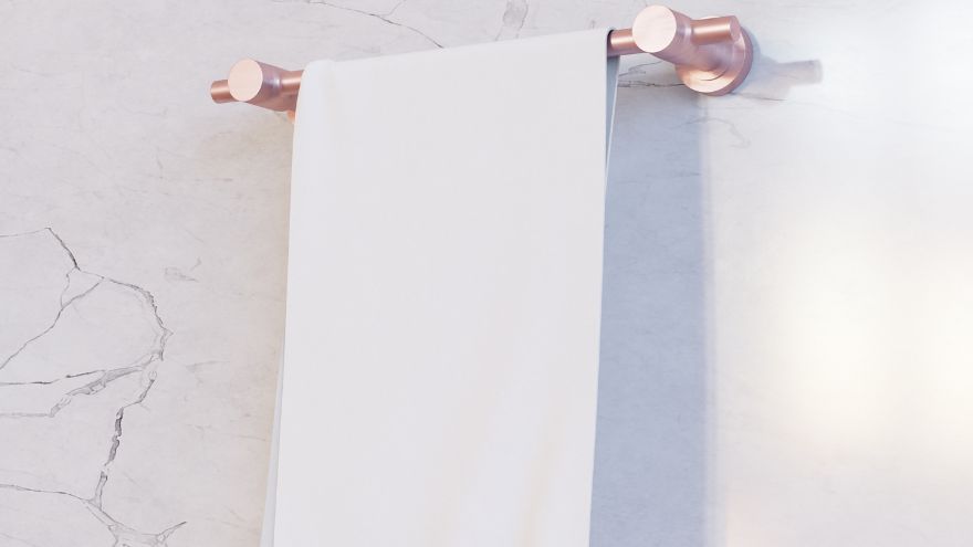 Miedziany wieszak na ręcznik na glazurowej ścianie w łazience