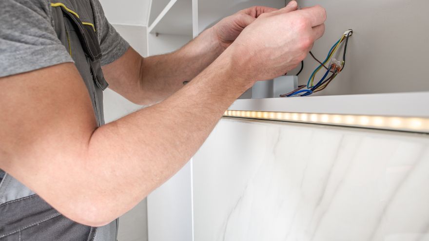 Instalator podłącza obwód elektryczny do listy LED w łazience