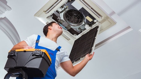 Instalator sprawdza działanie klimatyzacji sufitowej w biurze
