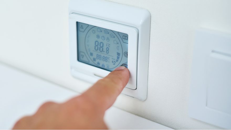 Instalator sprawdza działanie regulatora ogrzewania i wentylacji zamontowanego na ścianie