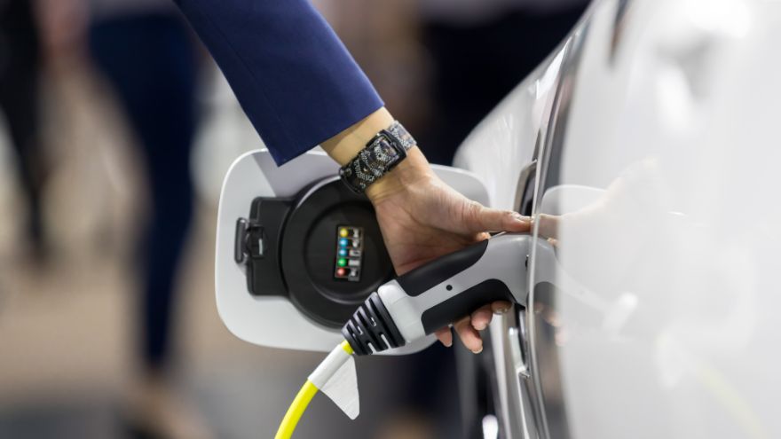 Kierowca ładuje samochód elektryczny z wallboxa ładowarką