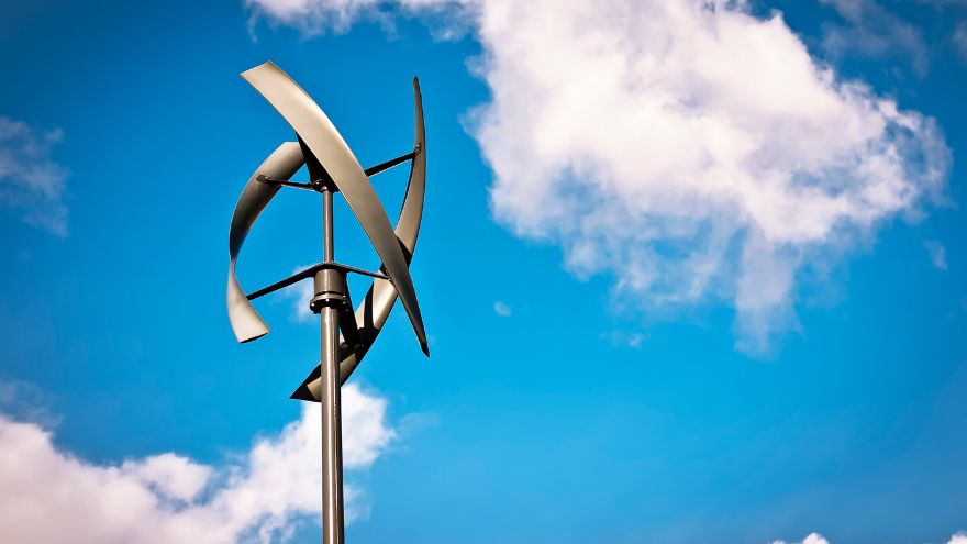 Domowa pionowa turbina wiatrowa na tle nieba z chmurami