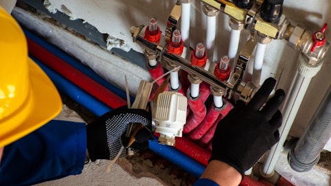 Instalator montuje do rozdzielacza ogrzewania podłogowego termostat