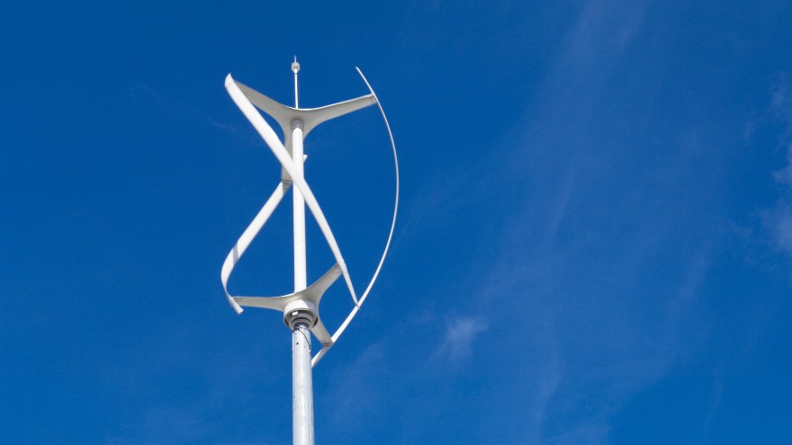 Turbina wiatrowa o osi pionowej na tle niebieskiego nieba