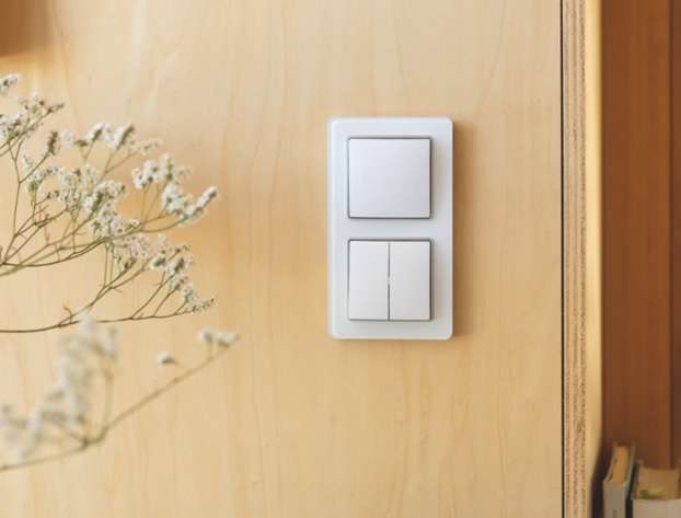 Łączniki Schneider Electric Sedna na drewnianej ścianie w instalacji elektrycznej