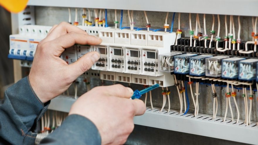 Elektryk sprawdza pomiar impedancji w obwodzie elektrycznym przy rozdzielnicy